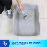 A person wearing gray sneakers cleans a large, gray Petmate Basic Litter Box made from EcoTech™ resin using a scooper. The open-top design offers easy access. A blue banner states: Easy access to scoop for easy cleaning.