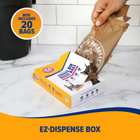A hand pulls a brown waste bag from an Arm & Hammer Swivel Bin Pet Waste Bags box labeled Includes 20 bags. These easy-to-dispense pet waste bags, enhanced with activated baking soda, are set against a white tile wall and black container.